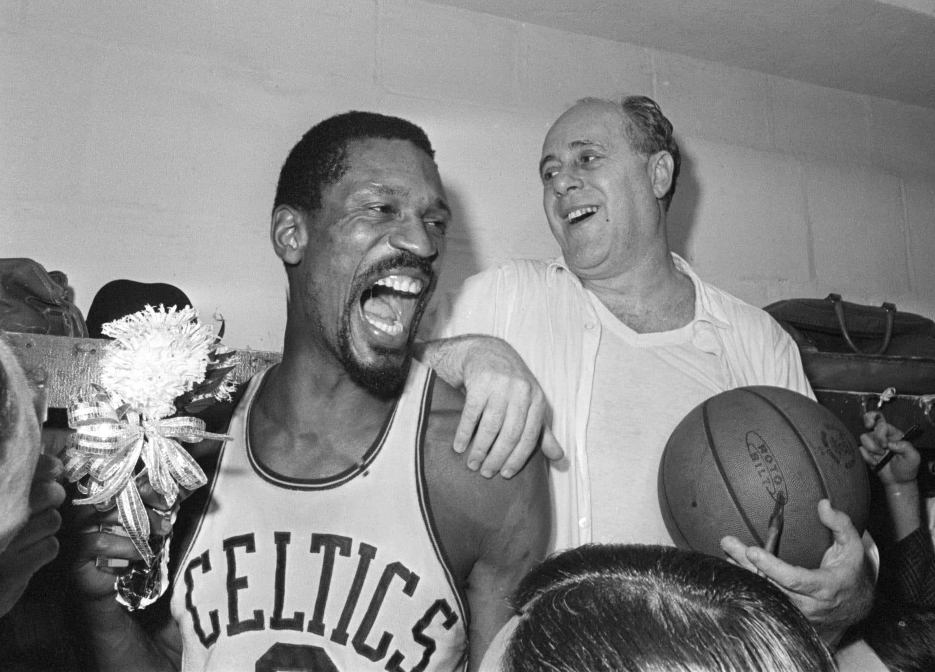 Bill Russell holds a corsage sent to the dressing room as he celebrates with Celtics coach Red Auerbach after defeating the Los Angeles Lakers, 95-93, to win their eighth-straight NBA Championship, in Boston, in this April 29, 1966, photo. (AP)