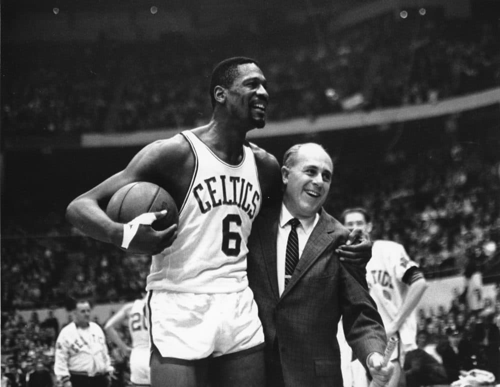 Bill Russell, left, star of the Boston Celtics is congratulated by coach Arnold &quot;Red&quot; Auerbach after scoring his 10,000th point in the NBA game against the Baltimore Bullets in Boston Garden on Dec. 12, 1964. The NBA great Bill Russell has died at age 88. His family said on social media that Russell died on Sunday, July 31, 2022. Russell anchored a Boston Celtics dynasty that won 11 titles in 13 years. (Bill Chaplis/AP)