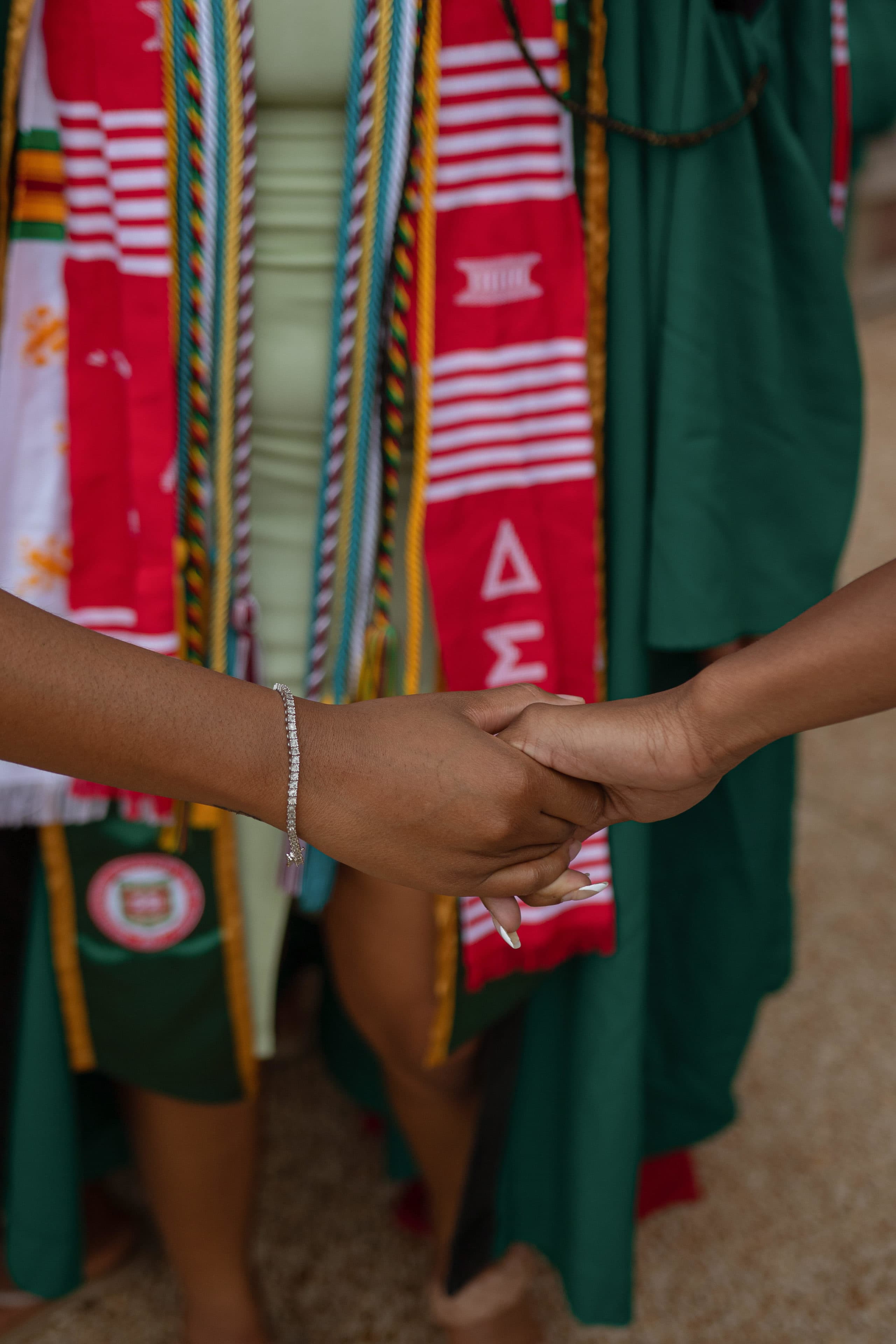 Delta Sigma Theta alum Madison Mikay holding another sorority sister's hand for their Washington University in St. Louis graduation pictures. (Courtesy of Madison Mikay)