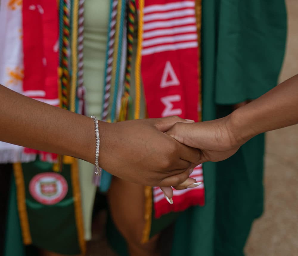Delta Sigma Theta alum Madison Mikay holding another sorority sister's hand for their Washington University in St. Louis graduation pictures. (Courtesy of Madison Mikay)