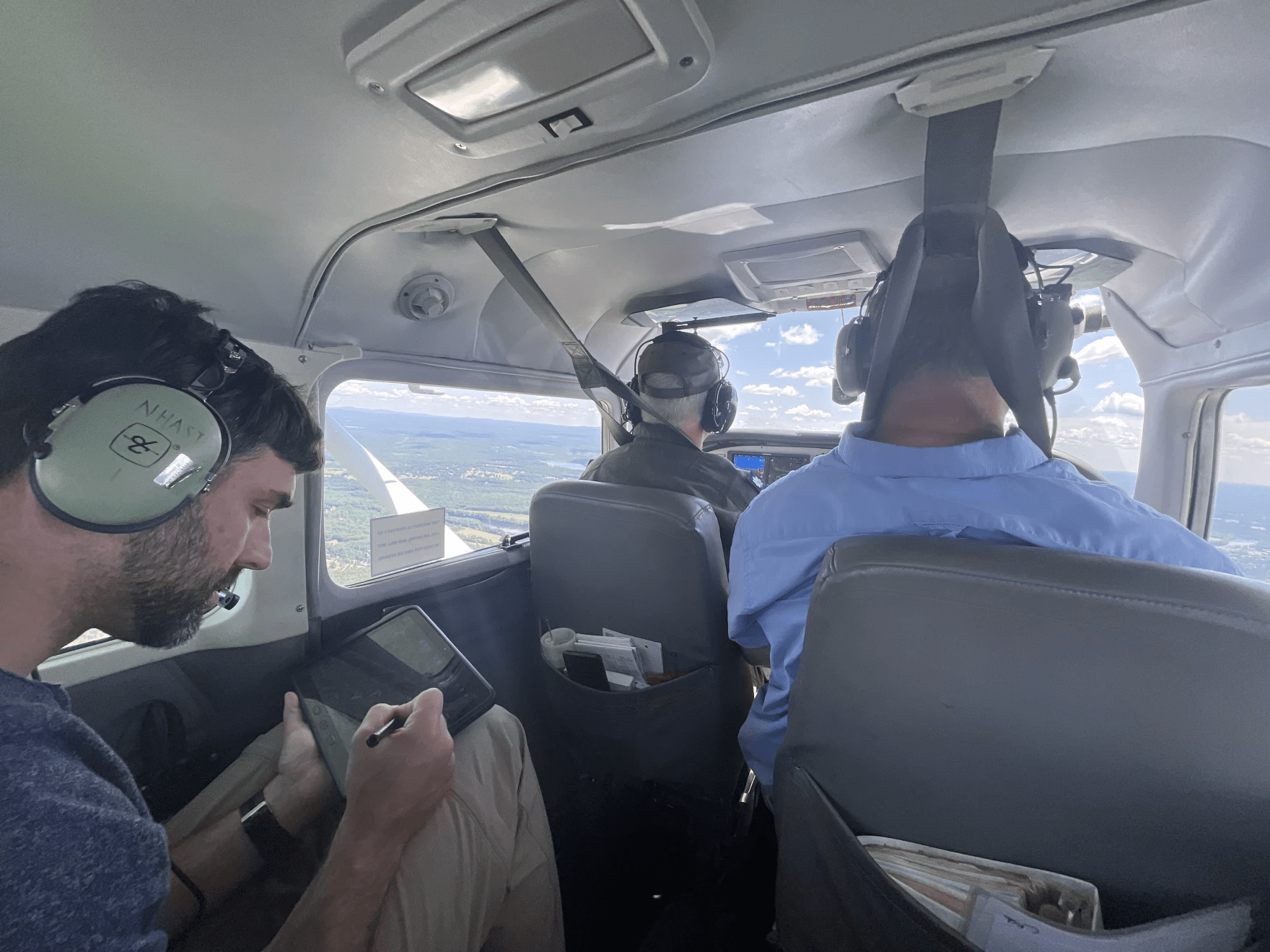 Davidson and Lombard record the shape of the damage they see from the airplane on digital tablets. (Mara Hoplamazian/NHPR)