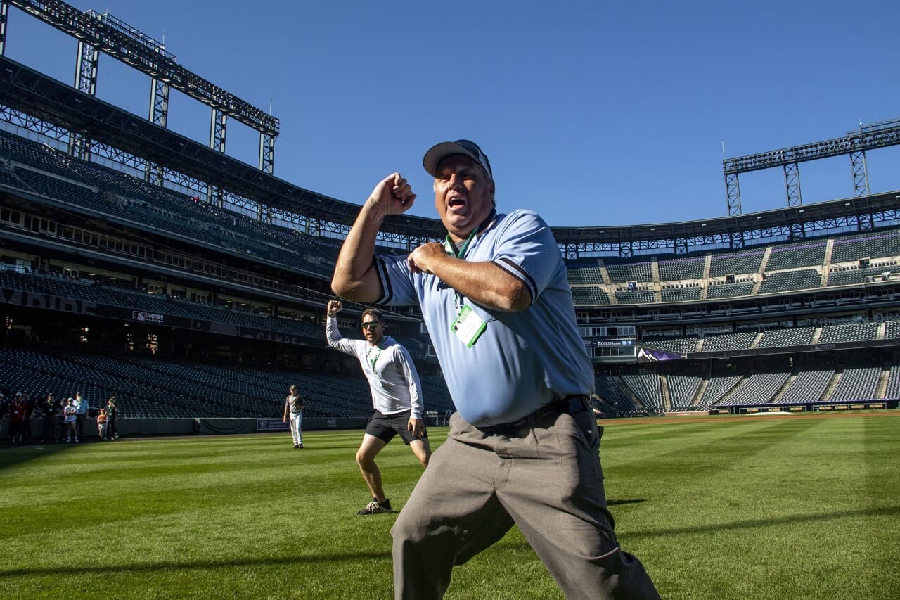 An umpire works on his strike call stance at a July 30 Major League Baseball-sponsored umpire clinic at Denver's Coors Field. (Kevin Beaty/Denverite)