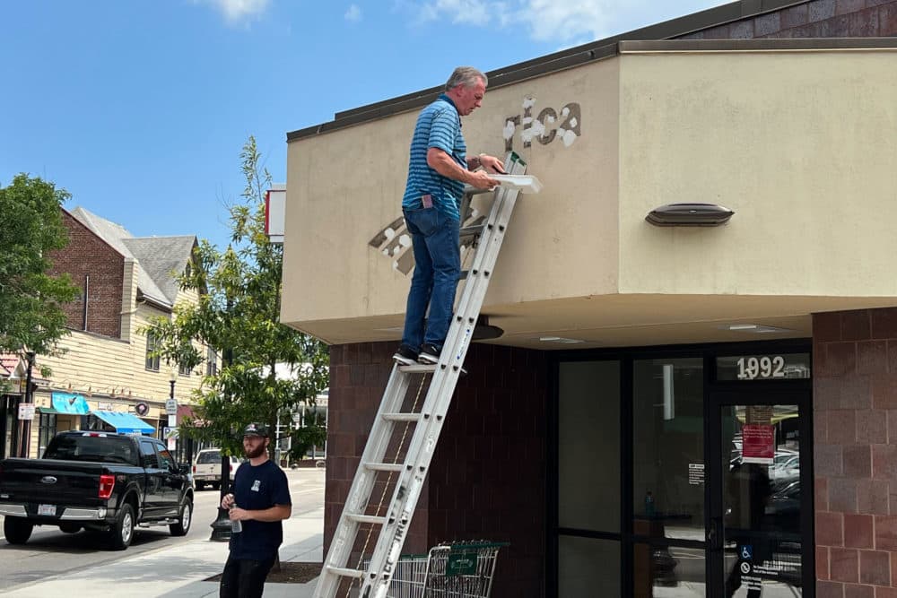 A Bank of America sign is removed from the bank's closed Roslindale branch. (Courtesy Adam Rogoff)