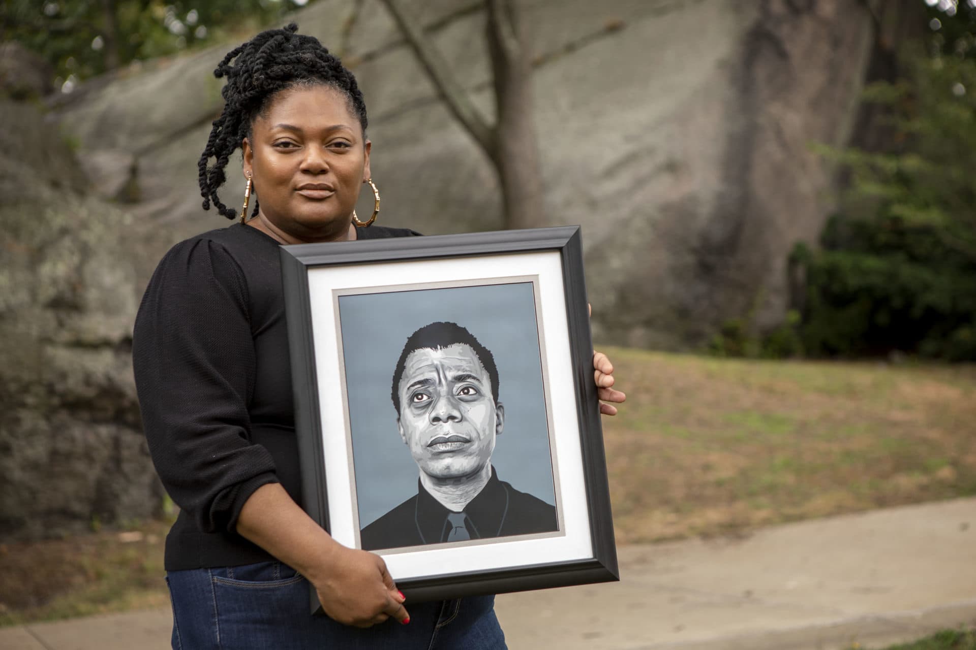 Anita Morson-Matra holds a portrait of James Baldwin. Morson-Matra is a creative entrepreneur, urban planner and founder of Baldwin in the Park and Nubian Nights. (Robin Lubbock/WBUR)