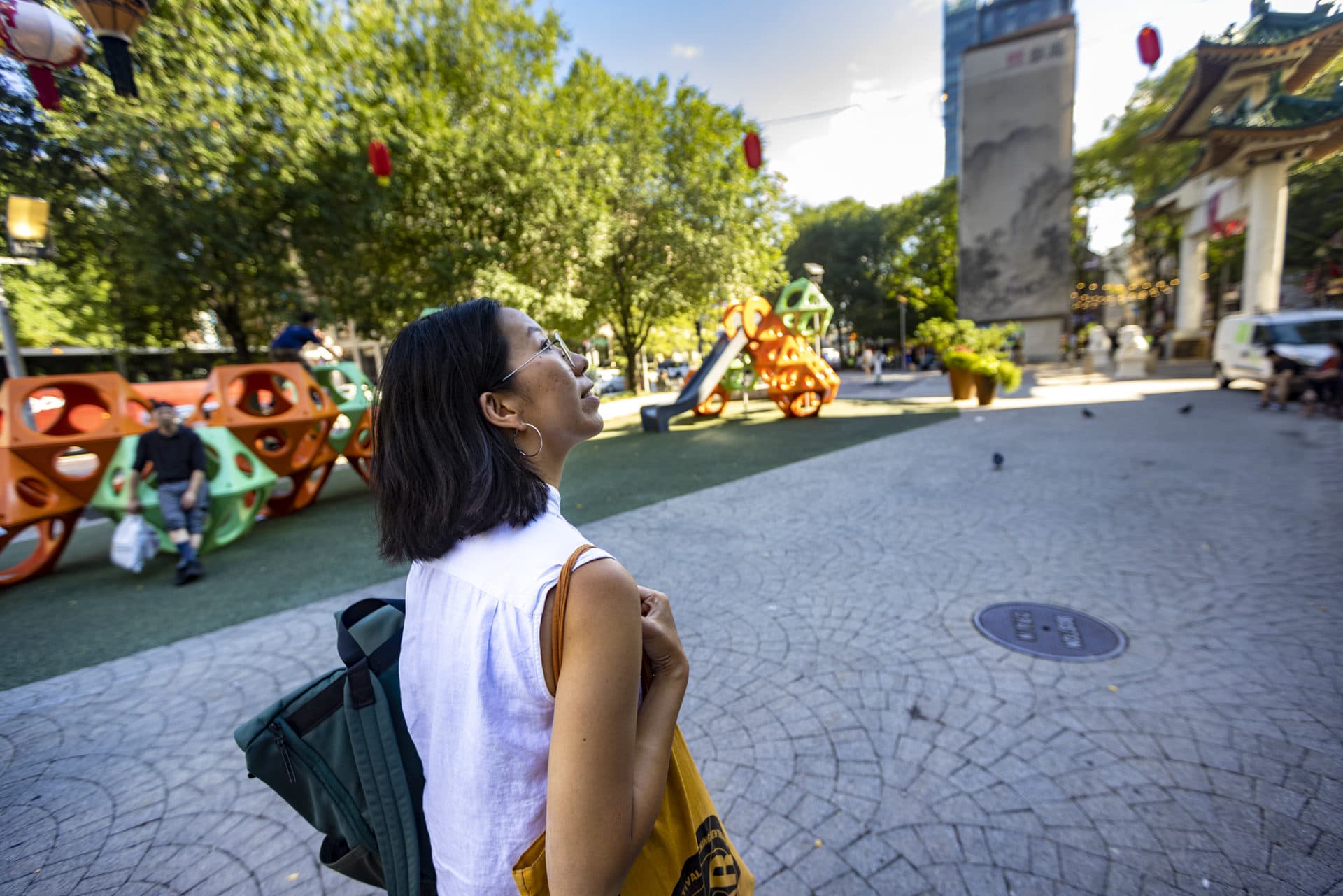 Artist Lily Xie looks up at the “Lantern Stories” installation by Yu-Wen Wu as she walks through Auntie Kay & Uncle Frank Chin Park on the Rose Kennedy Greenway. (Jesse Costa/WBUR)