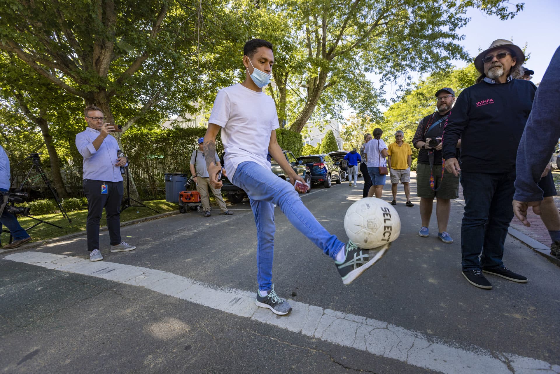 A migrant dribbles with a soccer ball on Winter Street out in front of St. Andrew’s Parish House in Edgartown. (Jesse Costa/WBUR)