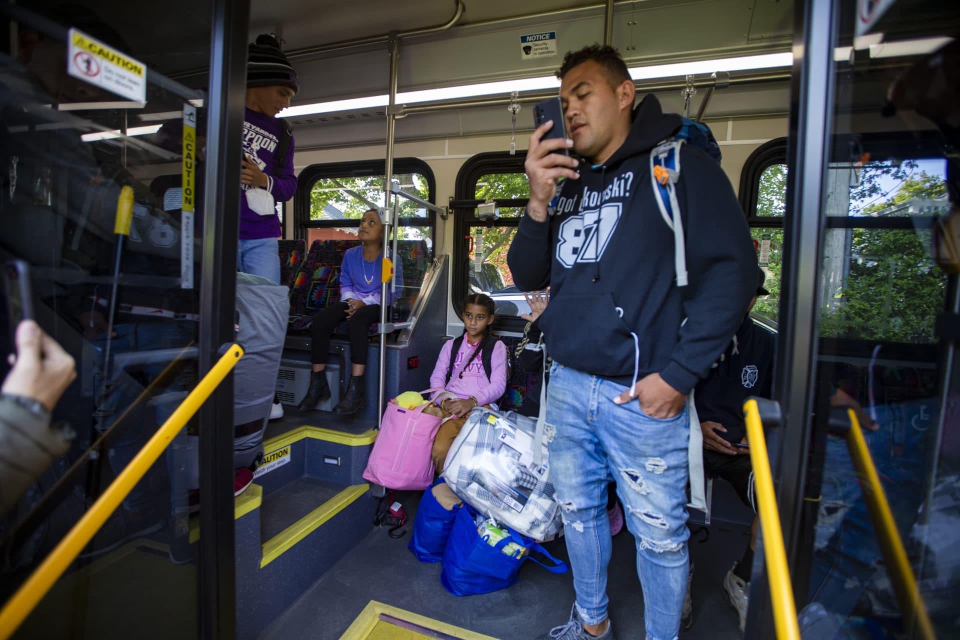 The Venezuelan immigrants board the first bus at St. Andrews Parish House as they moved to leave Martha’s Vineyard. (Jesse Costa/WBUR)