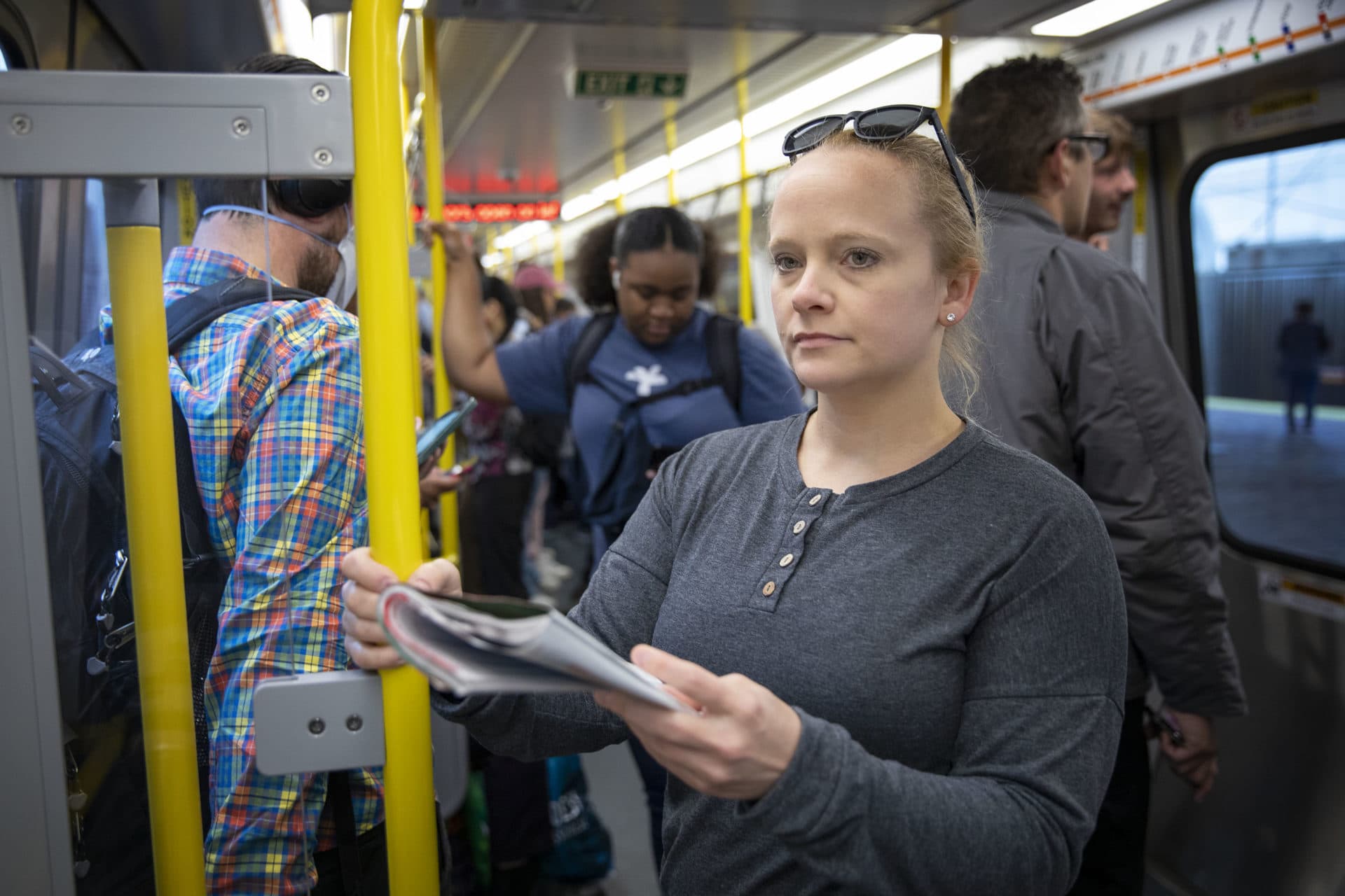 Leslie Good looks up from her magazine as she takes the Orange Line on her way to work. (Robin Lubbock/WBUR)