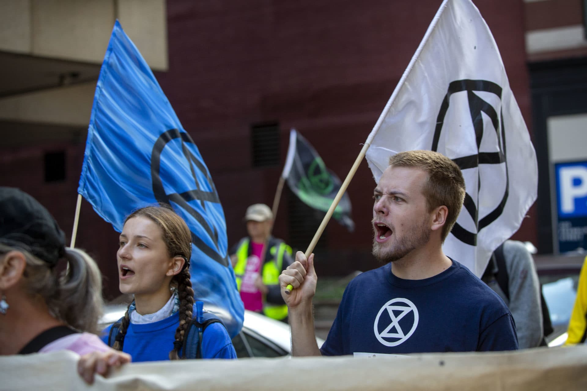 Extinction Rebellion protesters walk along Pearl St. in downtown Boston. (Robin Lubbock/WBUR)