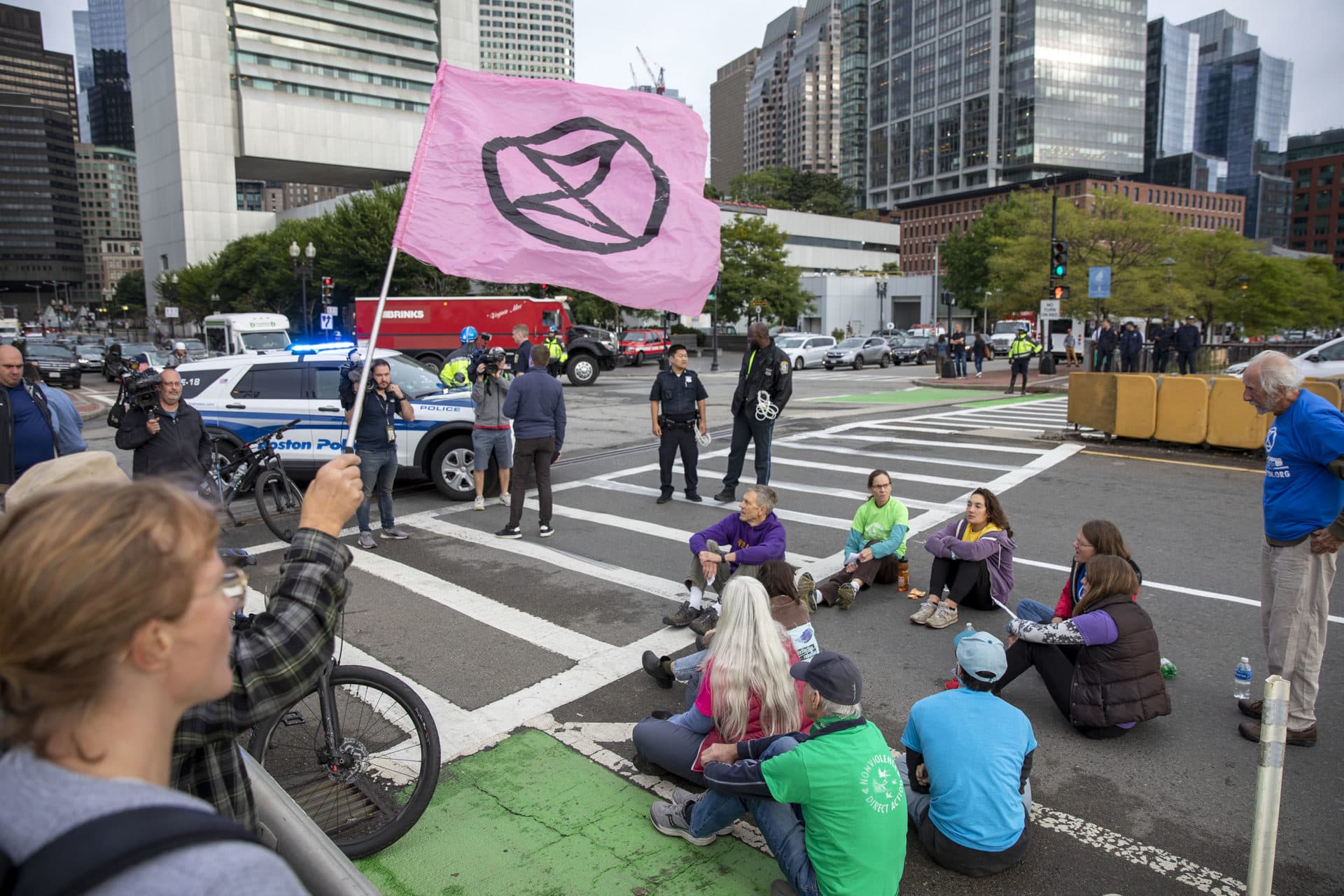 Extinction Rebellion protesters sit on Summer Street bridge. (Robin Lubbock/WBUR)