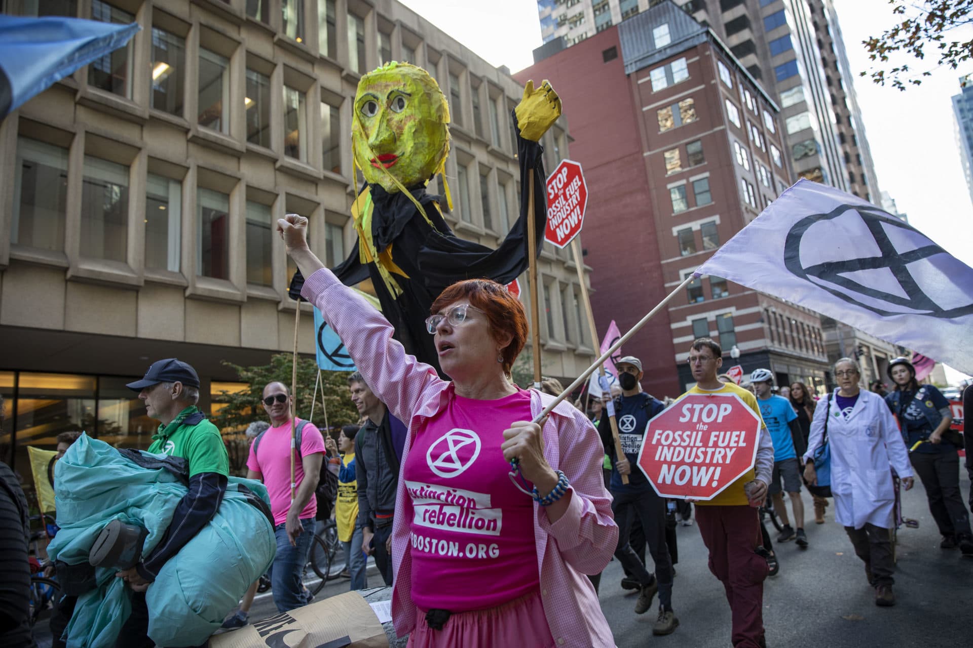 Extinction Rebellion protesters walk along Pearl St. in downtown Boston. (Robin Lubbock/WBUR)