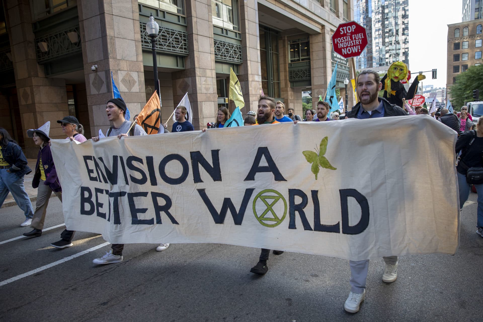 Extinction Rebellion protesters walk along Pearl St. in downtown Boston. (Robin Lubbock/WBUR)