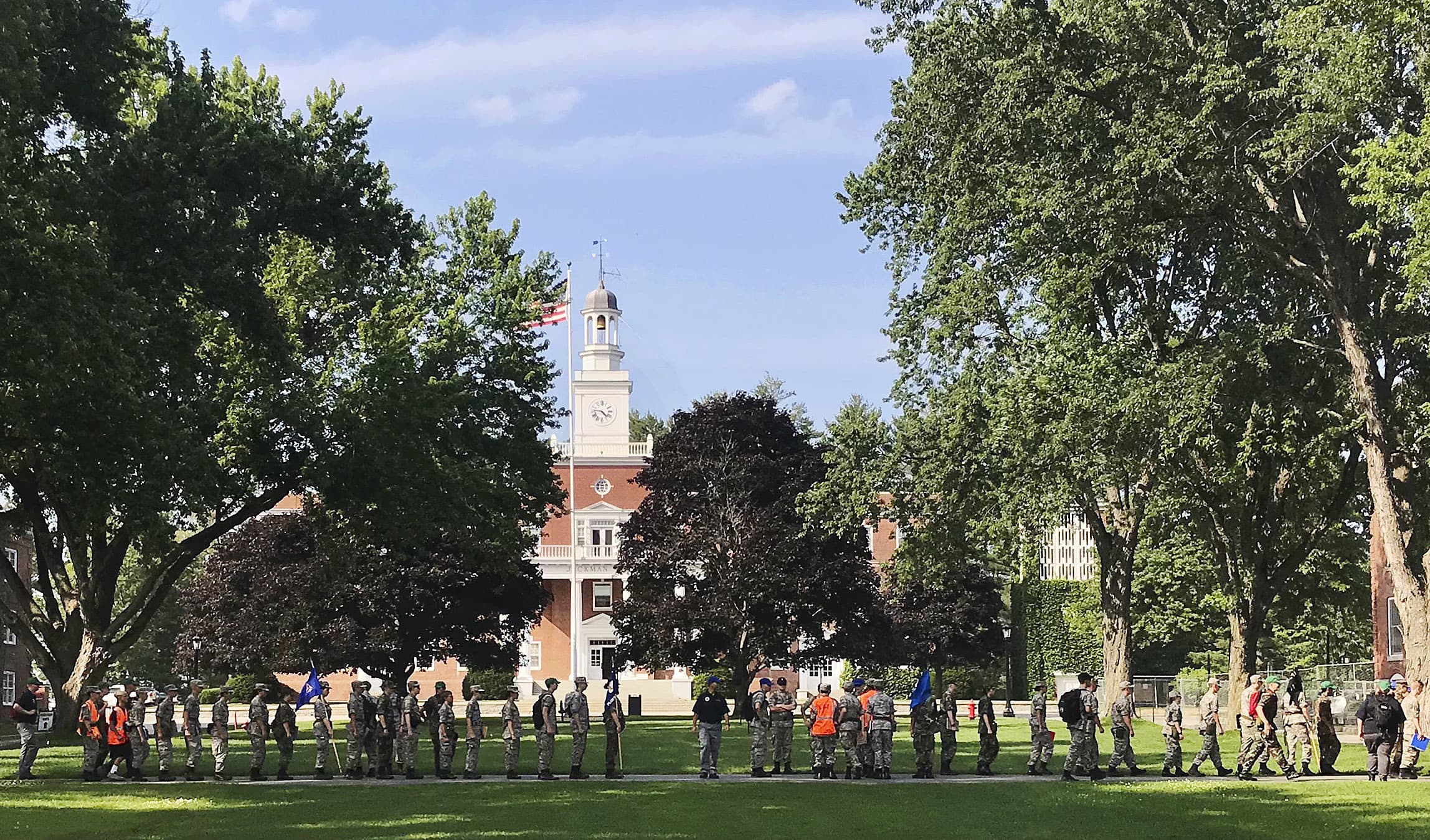 A group in military fatigues walks in front of Jackman Hall on the campus of Norwich University on July 16, 2018, in Northfield, Vt. (David Jordan/AP File)