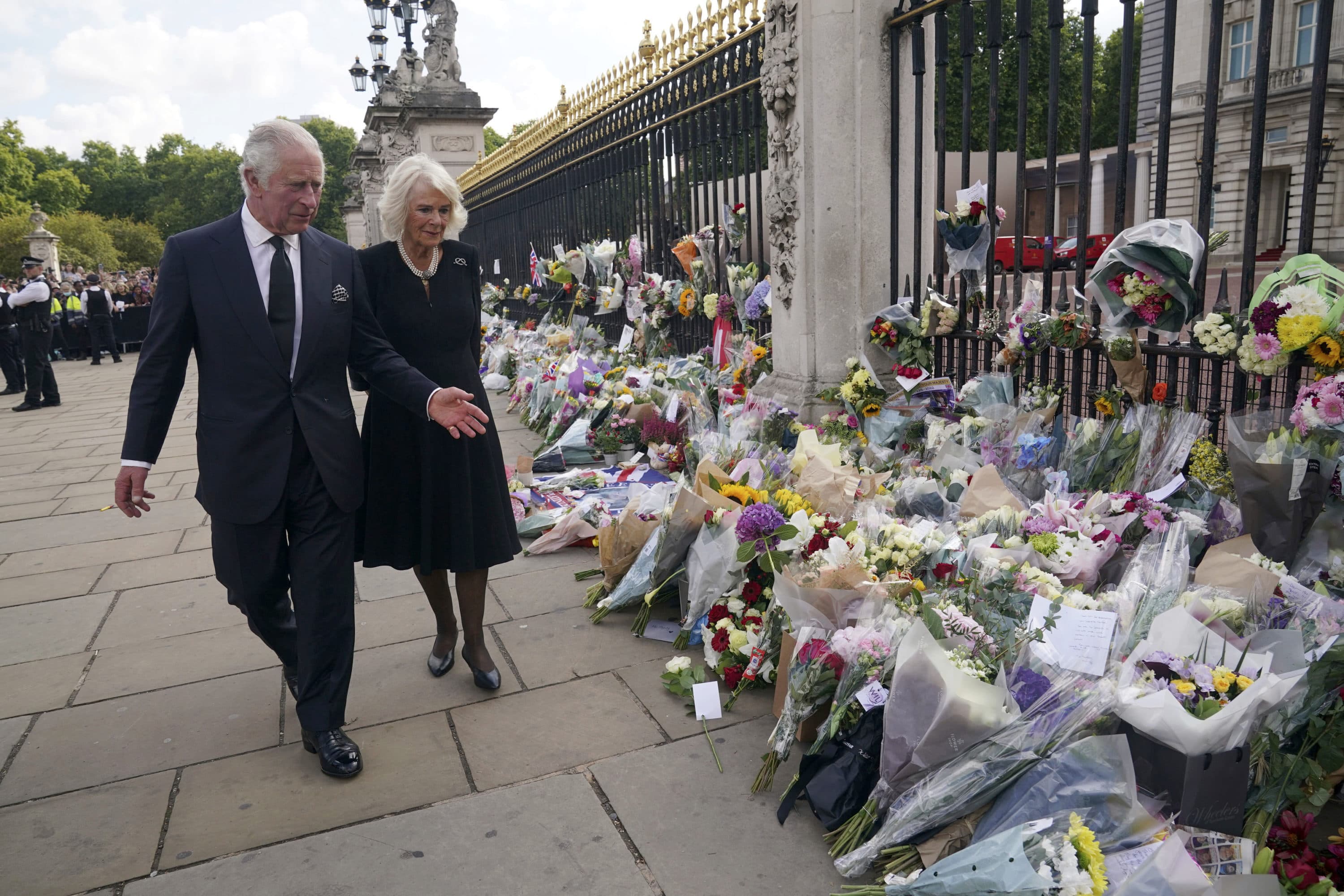 Britain's King Charles III, left, and Camilla, the Queen Consort, look at floral tributes outside Buckingham Palace following Thursday's death of Queen Elizabeth II, in London, Sept. 9. (Yui Mok/AP)