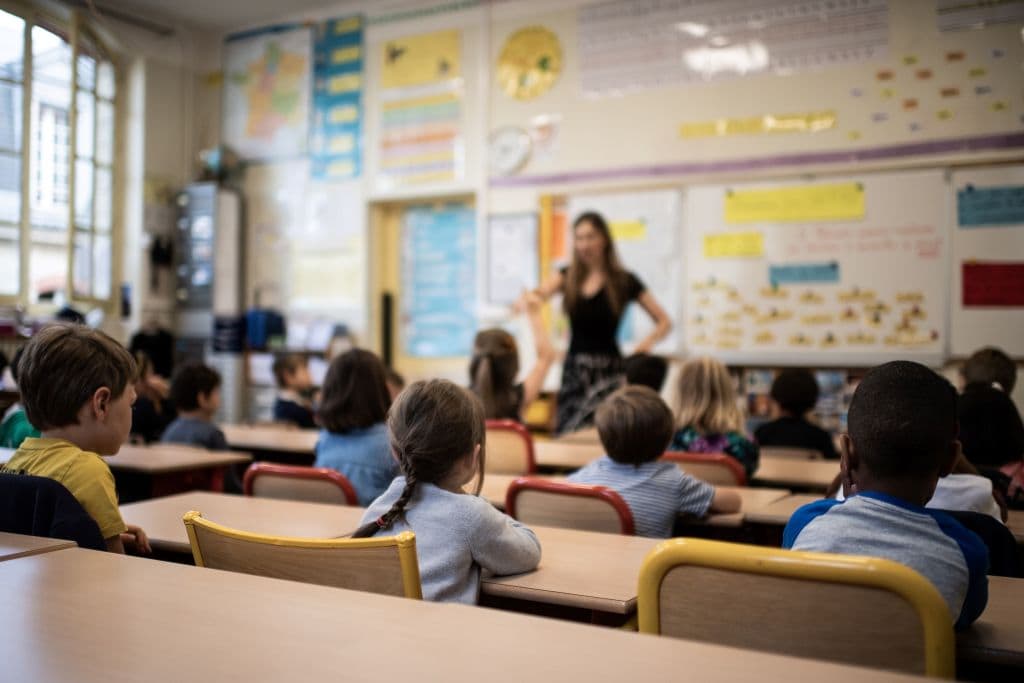 Children listen to their teacher as they sit in a classroom on the first day of the start of the school year, at the Chaptal elementary school in Paris, on September 2, 2019. (Martin Bureau/AFP via Getty Images)