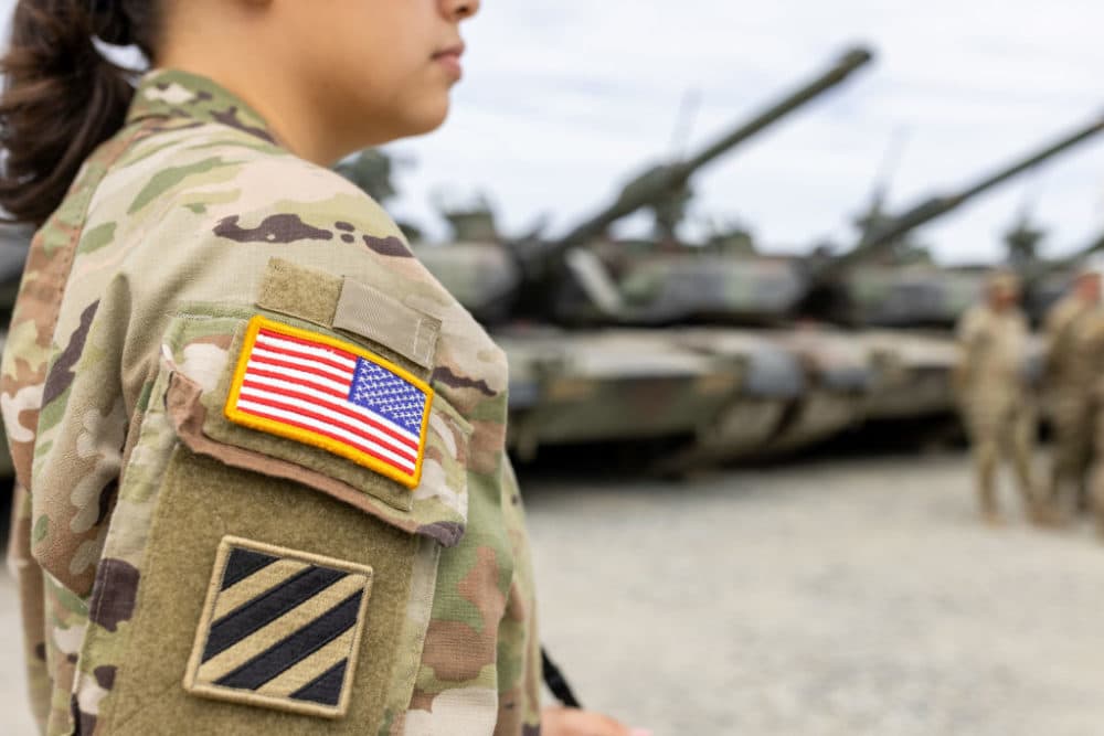A female U.S. Army soldier of the 1st Brigade of the 3rd Infantry Division stands in front of tanks during a visit by the German president to U.S. forces in Grafenwoehr. (Daniel Karmann/picture alliance via Getty Images)