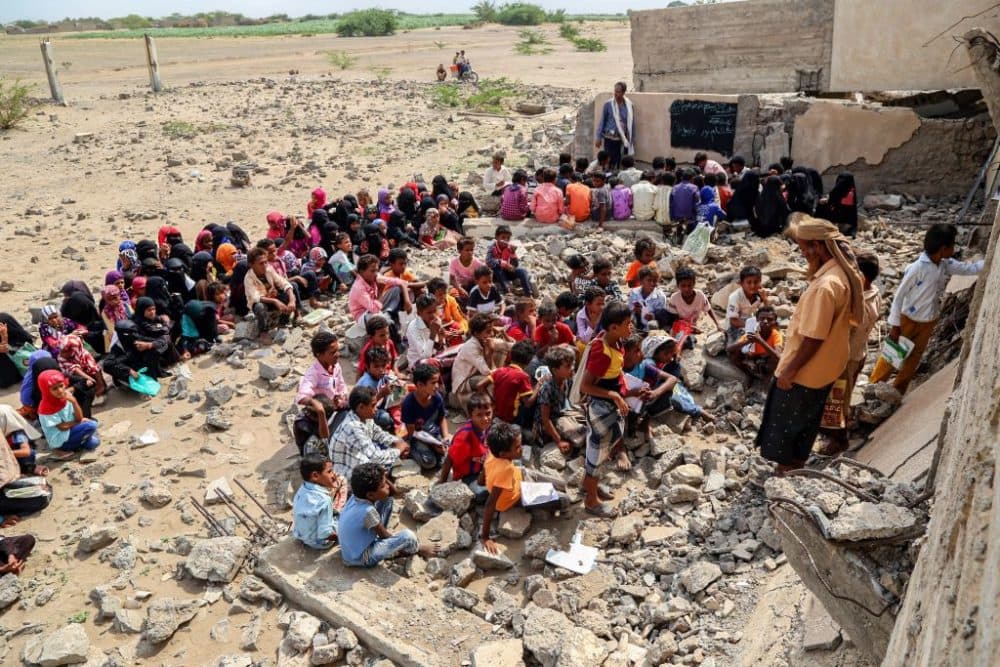 Children attend classes outdoors amidst the rubble of their destroyed school on the first day of the new academic year in Yemen's war-torn western province of Hodeida on August 21, 2022. (Khaled Ziad / AFP via Getty Images)