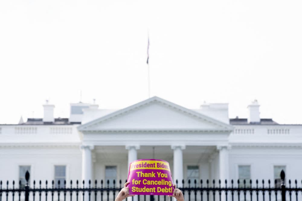 An activist holds a sign thanking President Biden for canceling some student debt, during a rally in front of the White House, on Aug. 25, 2022. (Stefani Reynolds/AFP via Getty Images)