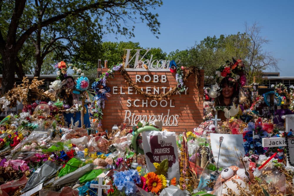 The Robb Elementary School sign is seen covered in flowers and gifts on June 17, 2022 in Uvalde, Texas. (Brandon Bell/Getty Images)