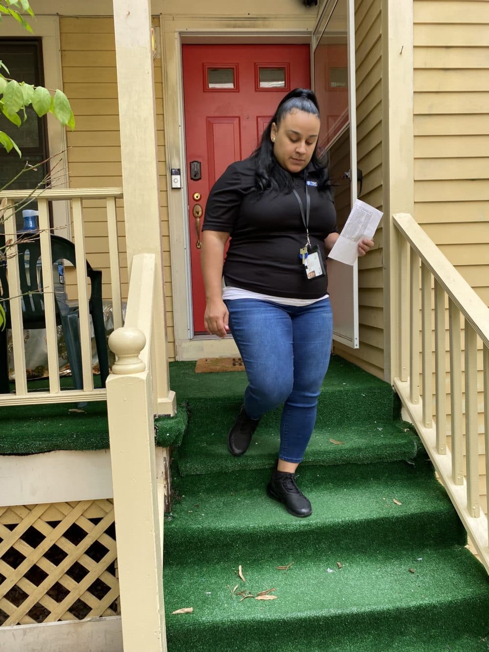 Angie Encarnacion, manager of the Boston Re-engagement Center, visits a home in Jamaica Plain as part of an effort to re-engage student attendance in the new school year. (Suevon Lee/WBUR)