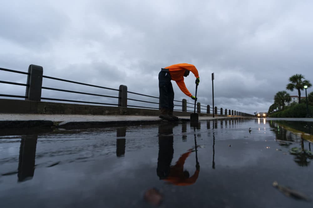 Corey Fields, with the city of Charleston, cleans a storm drain as effects from Hurricane Ian are felt, on Friday, in the Battery of Charleston, South Carolina. (Alex Brandon/AP)