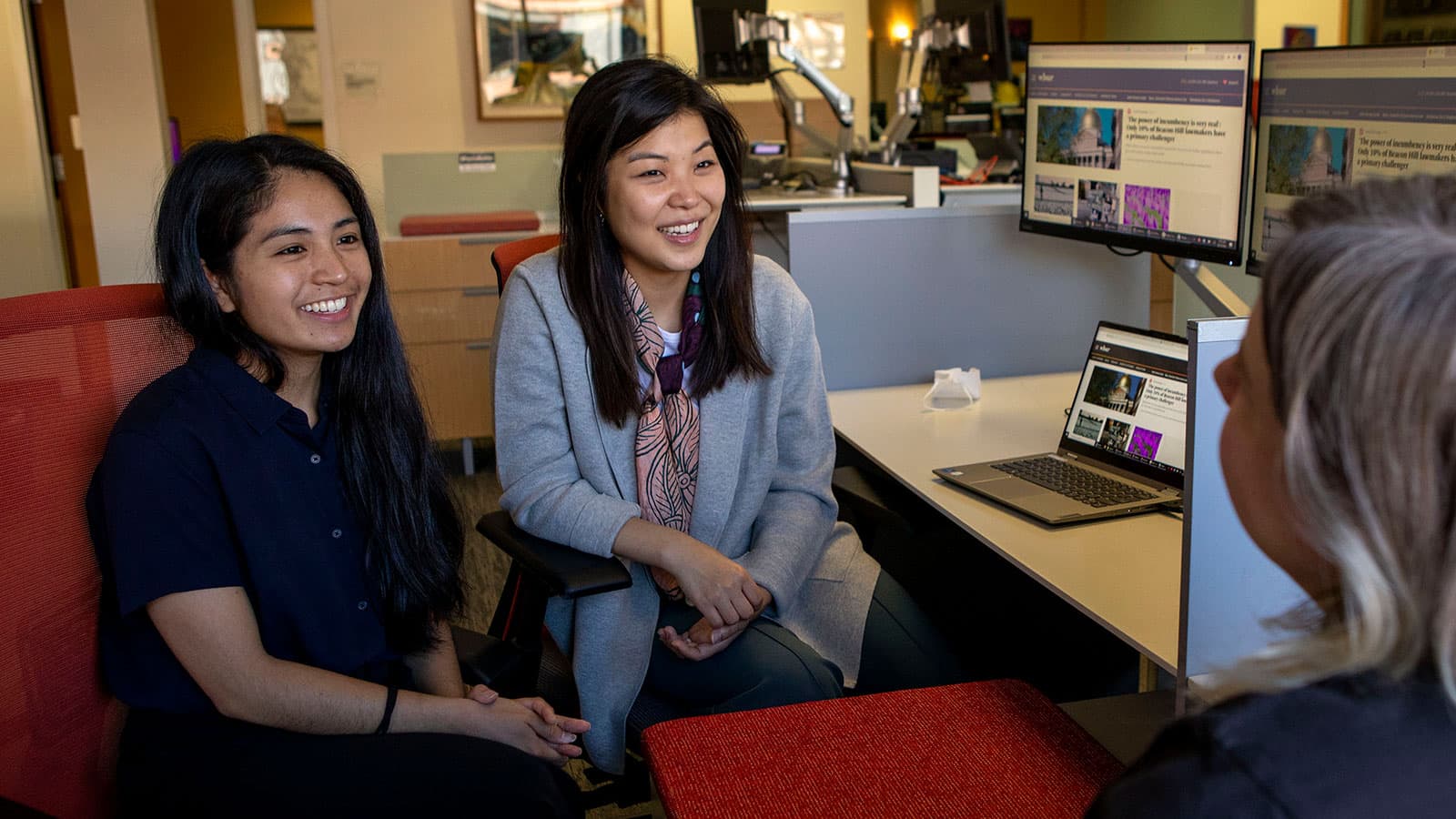 Newsroom fellows Vanessa Ochavillo (left) and Aimee Moon (right) chat with Meghan Kelly, multi-platform editor at WBUR. Credit: Robin Lubbock.