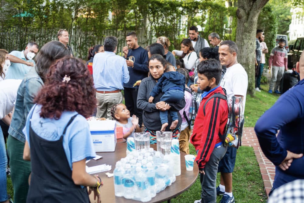 Migrants are supplied with water bottles and stand outside St. Andrew's Episcopal Church in Edgartown. (Ray Ewing/The Vineyard Gazette)