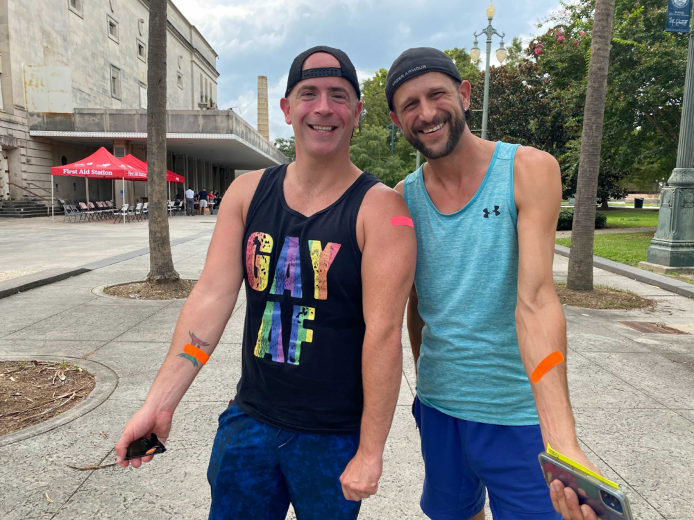 Anthony Reed (left) and Christopher Bowles (right) show off Band-Aids they received for their monkeypox vaccine jabs at the Southern Decadence Health Hub in Louis Armstrong Park in New Orleans, Sept. 6, 2022. (Shalina Chatlani/Gulf States Newsroom)