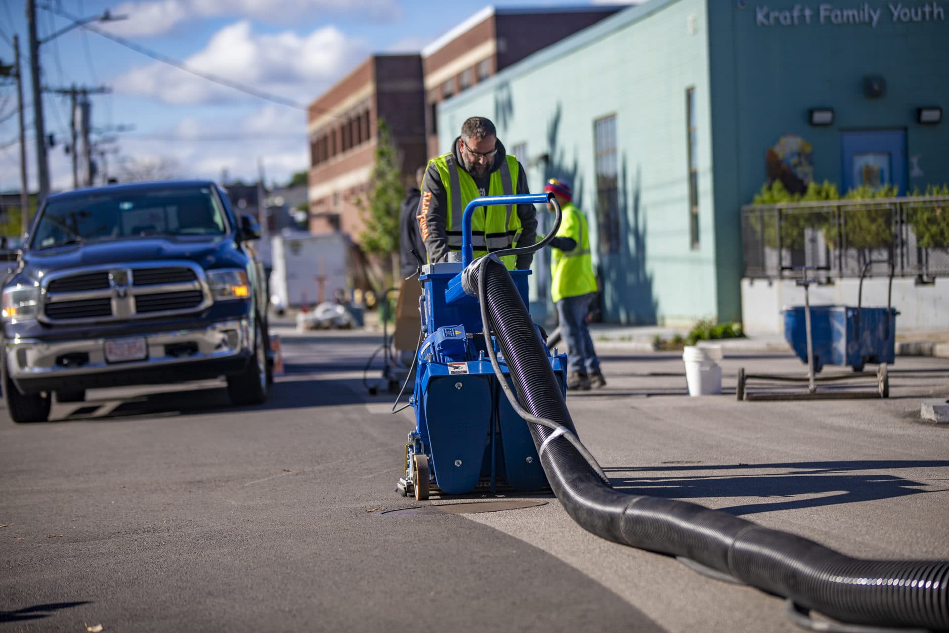 Workers grind down asphalt in Chelsea to minimize the amount of heat absorbed and reflected from the pavement surface. (Jesse Costa/WBUR)