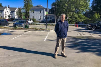 Kevin Beuttell, the supervising landscape architect for Cambridge, stands in a lot the city painted so it would reflect more heat back into the atmosphere. (Martha Bebinger/WBUR)