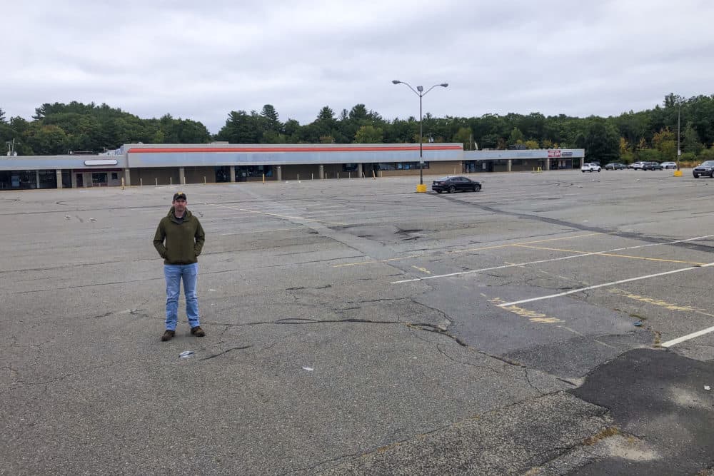 Nick Erickson, public works commissioner in Fitchburg, stands in a &quot;sea of asphalt&quot; — one of the parking lots Erickson says are too big for today's needs. (Martha Bebinger/WBUR)