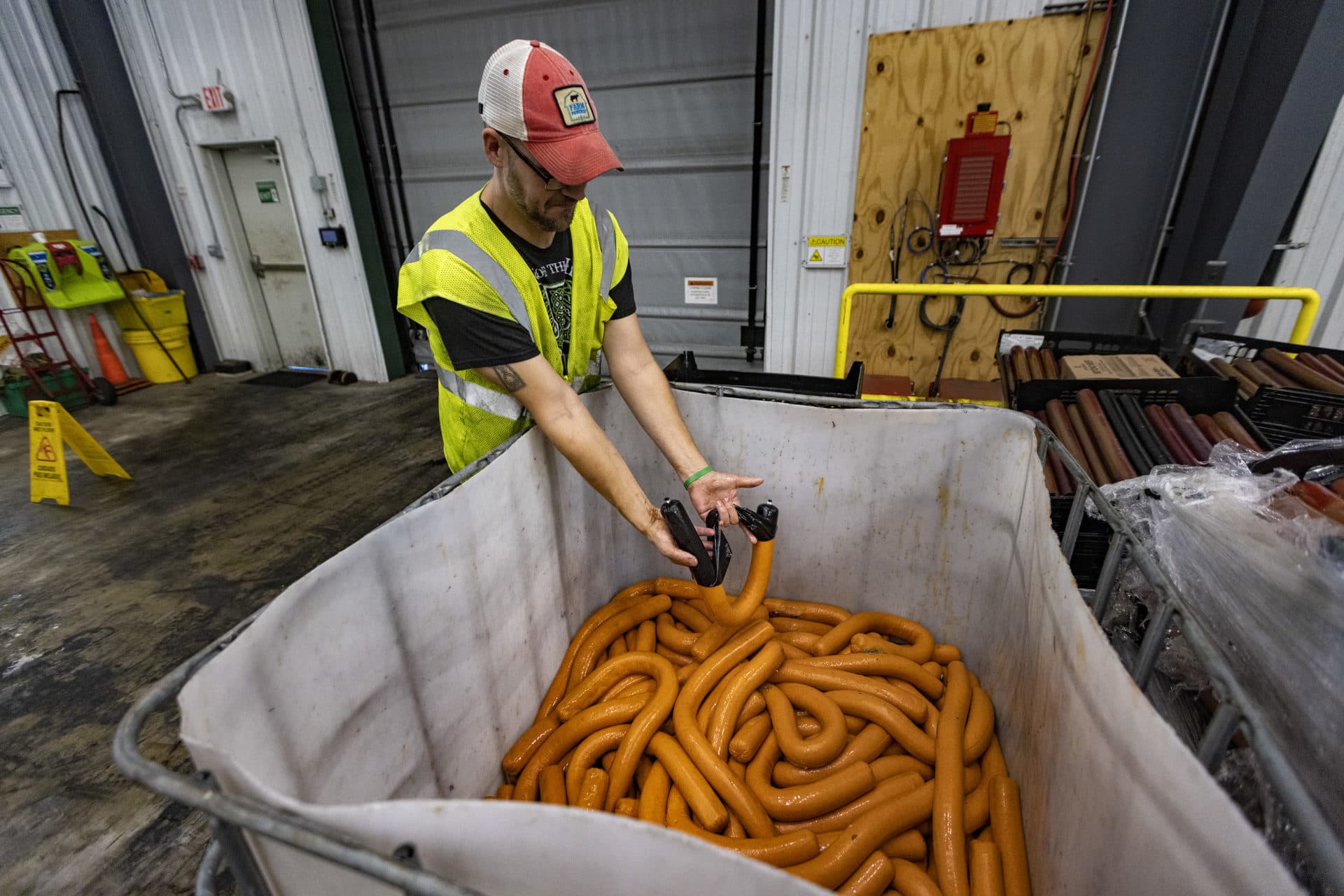 Vegan pepperoni being removed from its packaging before being processed at the Vanguard Renewables Organics Recycling Facility in Agawam. (Jesse Costa/WBUR)