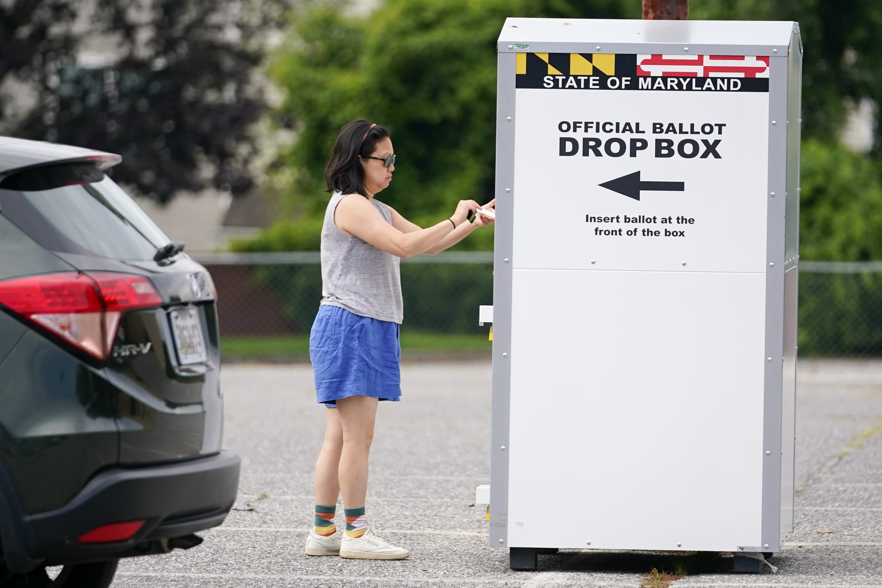 A woman drops a ballot into a drop box, casting her vote during Maryland's primary election, Tuesday, July 19, 2022, in Baltimore. (Julio Cortez/AP)