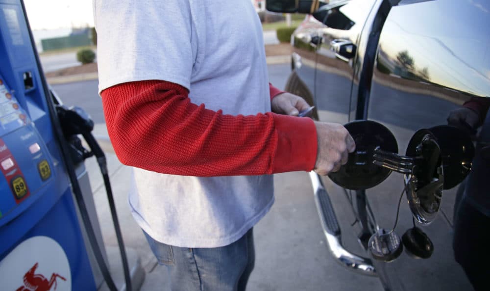 A customers opens the fuel door on his pickup truck before pumping gas. (Stephan Savoia/AP)