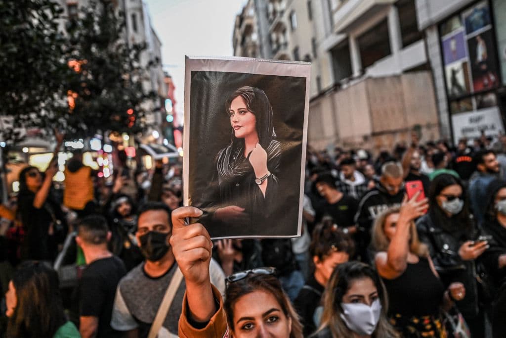 A protester holds a portrait of Mahsa Amini during a demonstration in support of Amini, a young Iranian woman who died after being arrested in Tehran by the Islamic Republic's morality police, on Istiklal avenue in Istanbul on September 20, 2022. - Amini, 22, was on a visit with her family to the Iranian capital when she was detained on September 13 by the police unit responsible for enforcing Iran's strict dress code for women, including the wearing of the headscarf in public. She was declared dead on September 16 by state television after having spent three days in a coma. (Photo by Ozan KOSE / AFP) (Photo by OZAN KOSE/AFP via Getty Images)