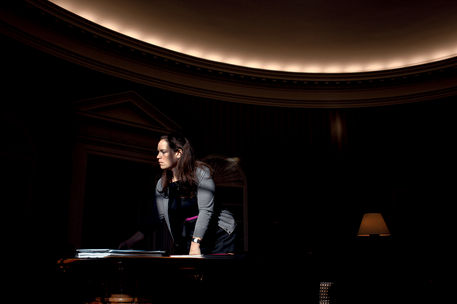 Personal Secretary Katie Johnson leans on the Resolute Desk while listening to the President in 2010. Copyright © 2022 by Pete Souza. (Courtesy of Pete Souza)