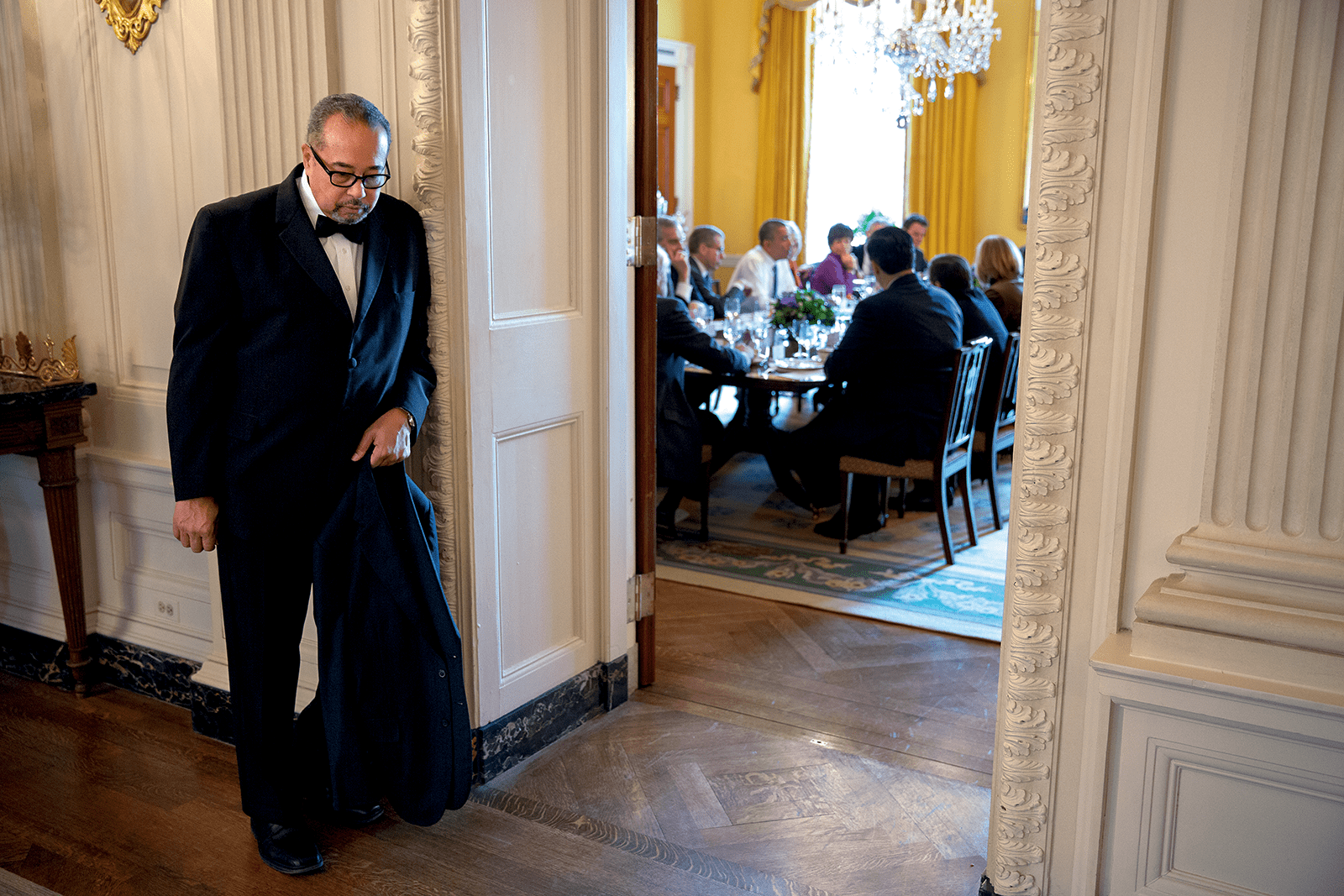 White House butler Von Everett holding President Obama’s suit coat during a luncheon with TV anchors. Copyright © 2022 by Pete Souza. (Courtesy of Pete Souza)