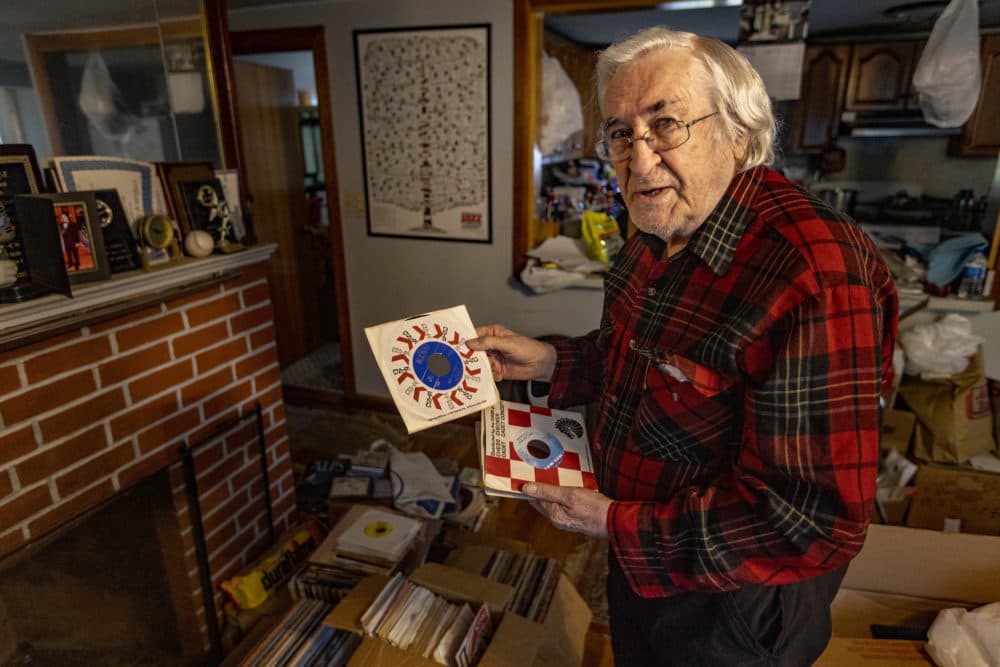 Skippy White pulls out James Brown’s “Don’t Be A Dropout” from a stack of 45 records from his collection. (Jesse Costa/WBUR)