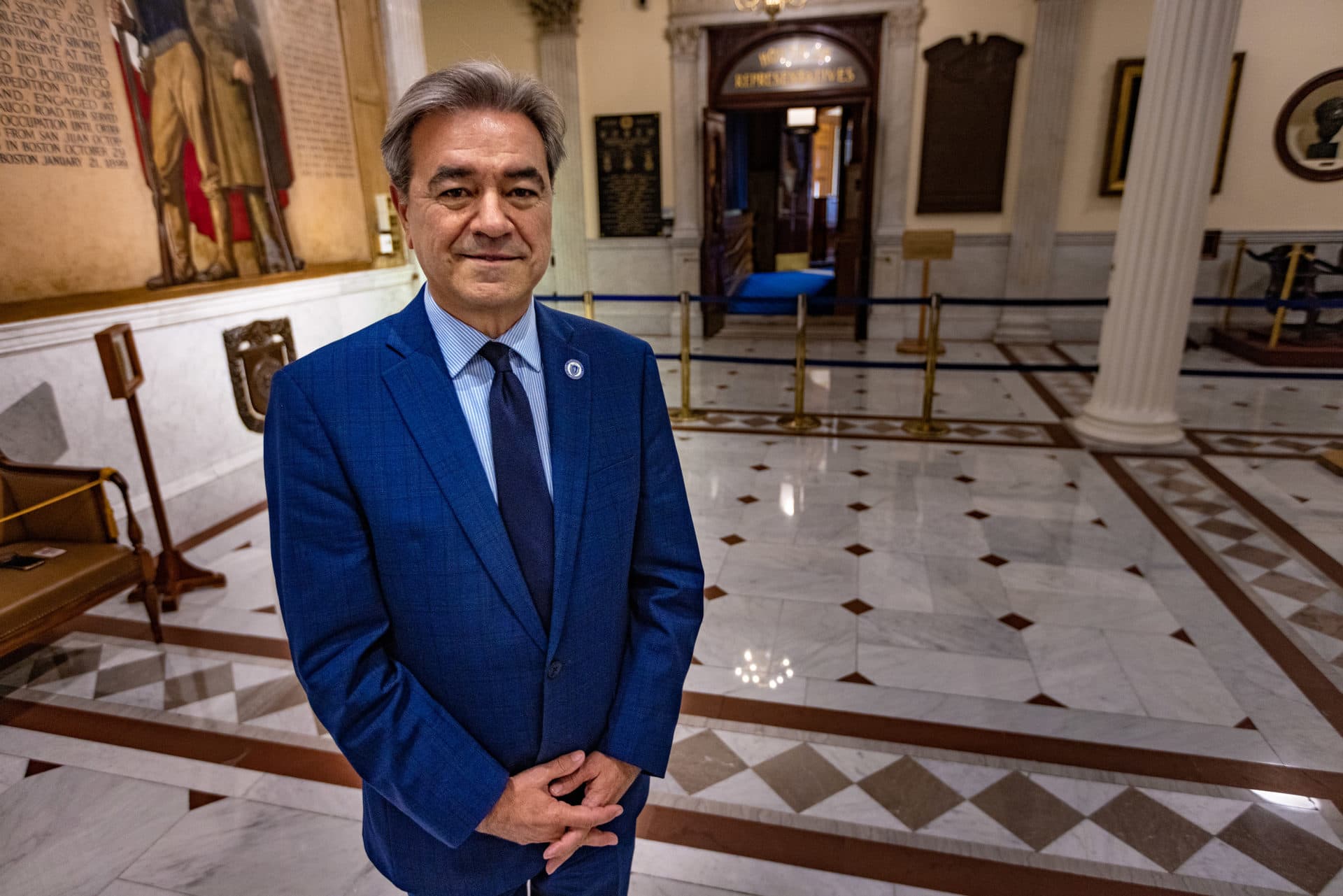 State Rep. Antonio Cabral stands outside the doors of the House chamber at the Massachusetts State House. (Jesse Costa/WBUR)