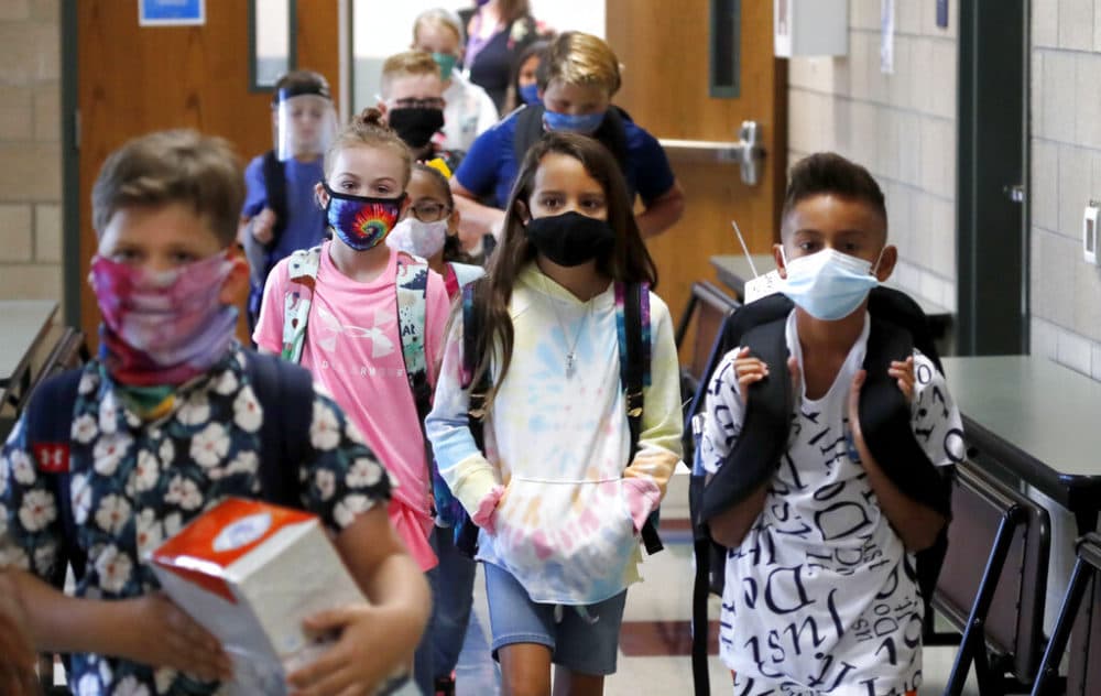 Wearing masks to prevent the spread of COVID19, elementary school students walk to classes to begin their school day in Godley, Texas, Wednesday, Aug. 5, 2020. (LM Otero/AP)