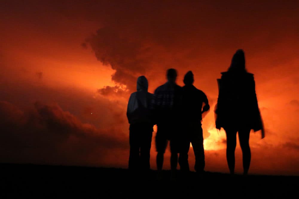 People watch the glow from lava erupting from Hawaii's Mauna Loa volcano, Monday, Nov. 28, 2022 in Hilo, Hawaii. (Caleb Jones/AP)