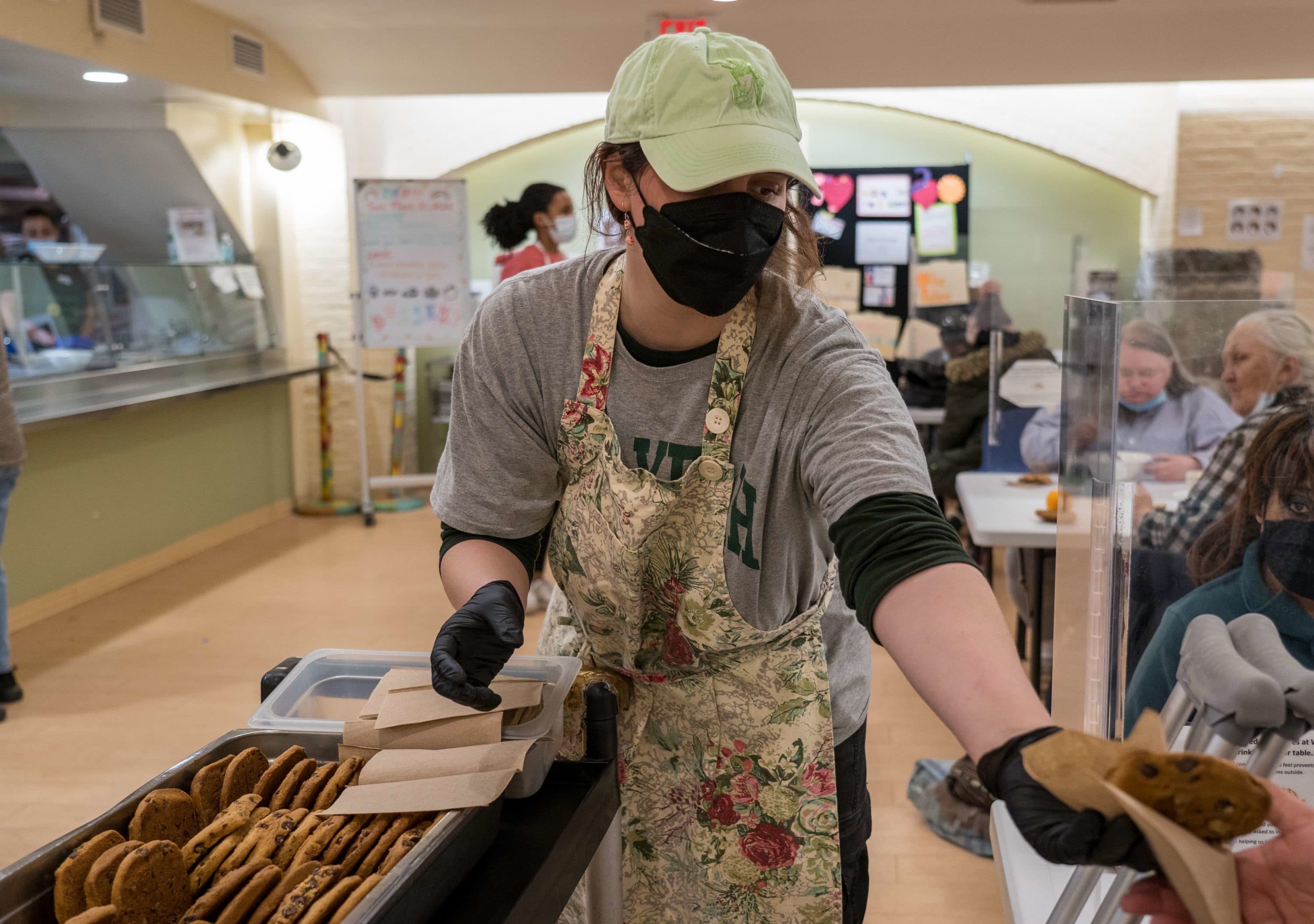 Women's Lunch Place staff member Caroline Saracena serves cookies to guests at their tables. (Courtesy Women's Lunch Place)