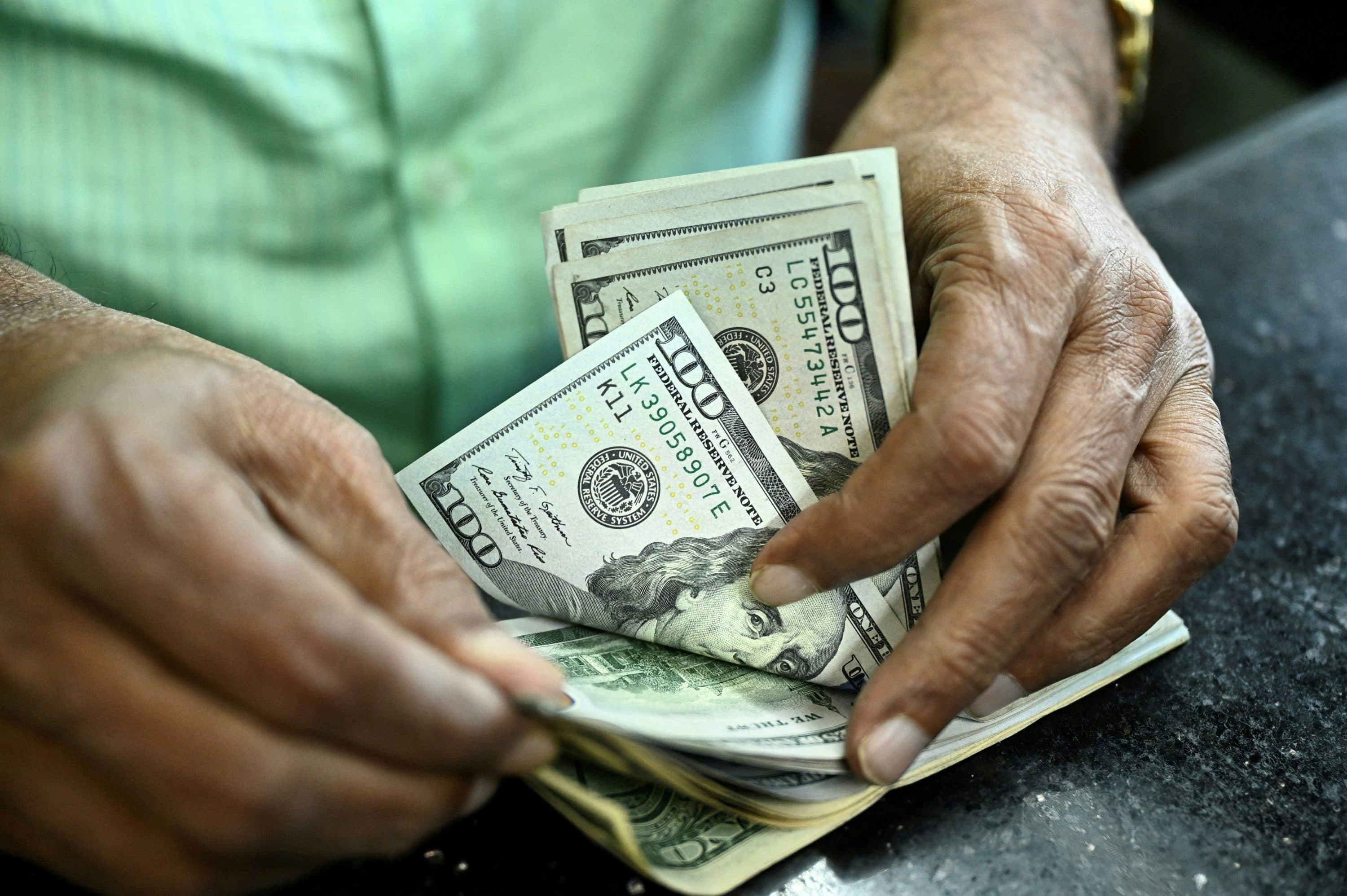 A man counts U.S. dollars. (Munir uz zaman/AFP via Getty Images)