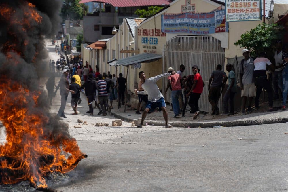 A man holds a stone as protesters demand the release of Haitian journalist Robest Dimanche, who was detained while covering a protest, in Port-au-Prince, Haiti. (Richard Pierrin/AFP via Getty Images)