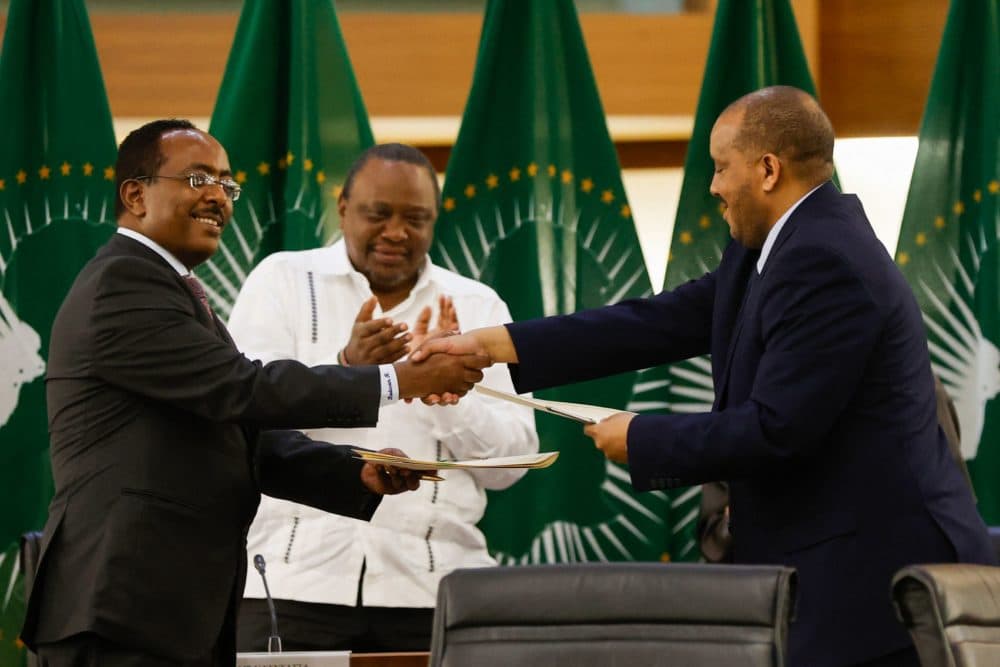 Redwan Hussein (L), Representative of the Ethiopian government, and Getachew Reda (R), Representative of the Tigray People's Liberation Front (TPLF), shake hands a peace agreement between the two parties. (Phill Magakoe/AFP via Getty Images)