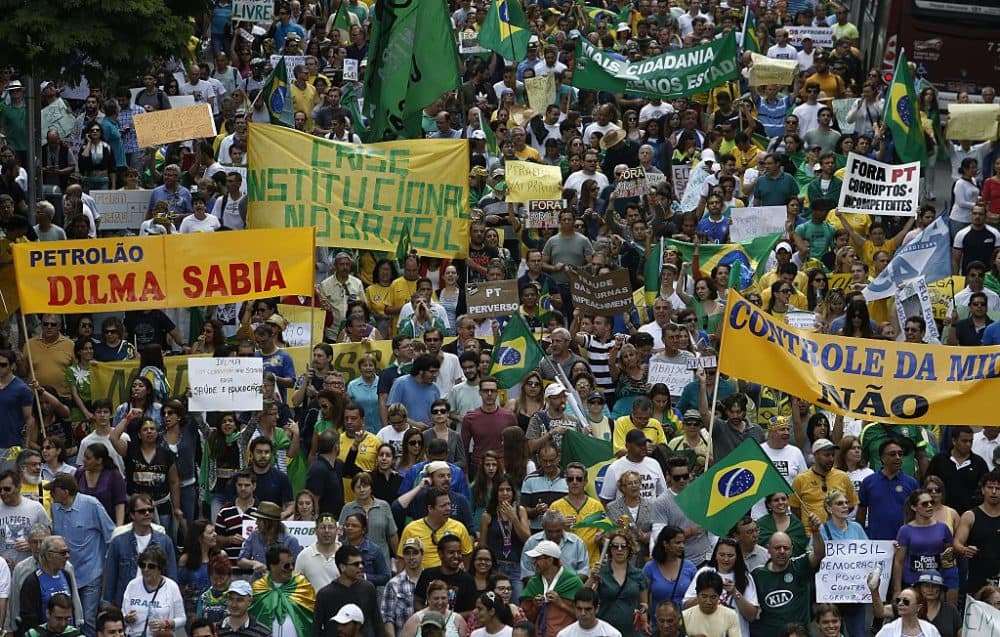 Demonstrators hold banners reading &quot;Institutional crisis in Brazil&quot; and &quot;Dilma knew&quot; as they take part in a protest demanding the impeachment of Brazilian re-elected President Dilma Rousseff in Sao Paulo, Brazil on November 15, 2014. AFP PHOTO / Miguel SCHINCARIOL        (Photo credit should read Miguel Schincariol/AFP via Getty Images)