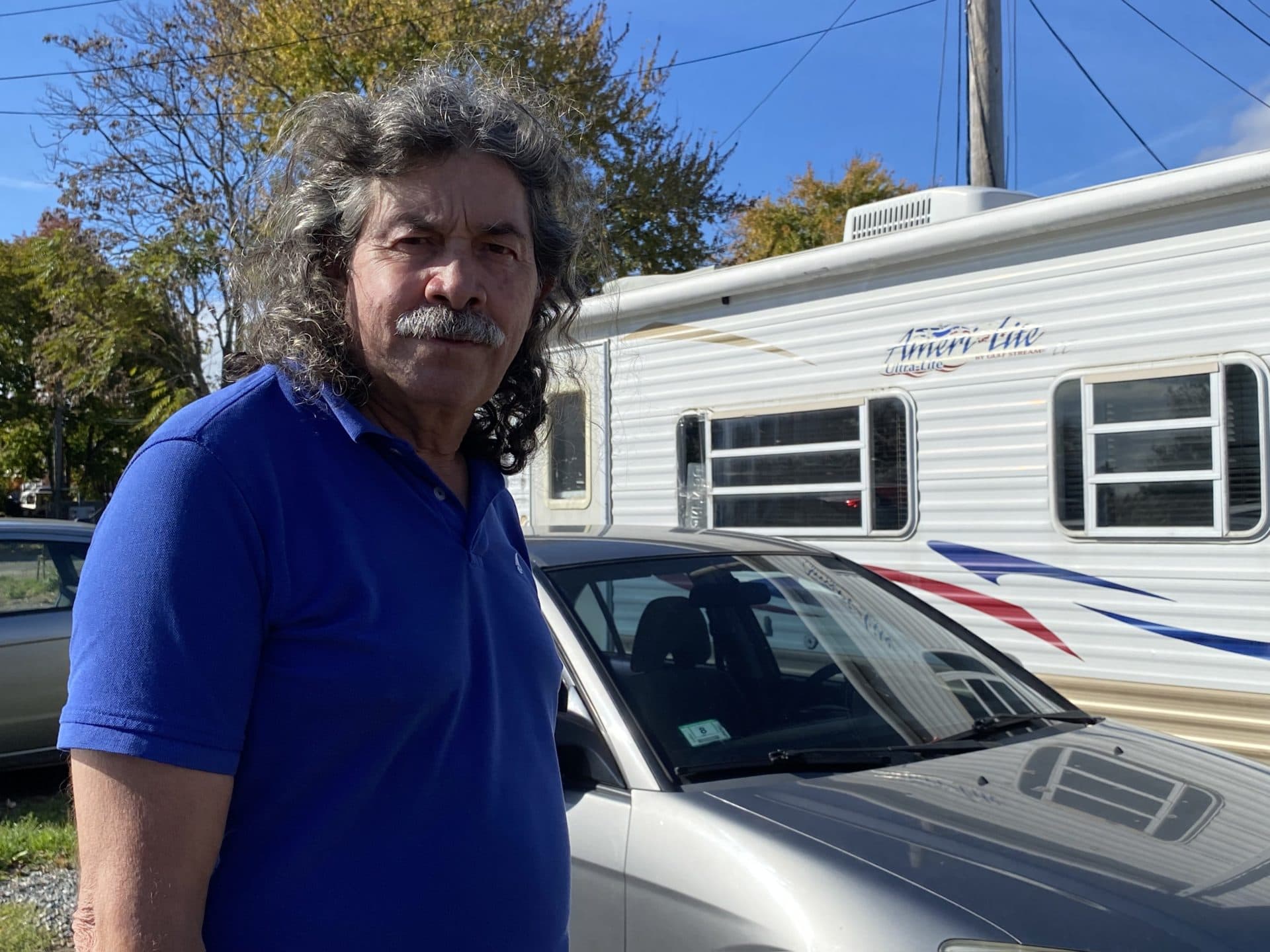 William Villanueva stands beside the RV he's looking to relocate after he leaves the park. (Simón Rios/WBUR)
