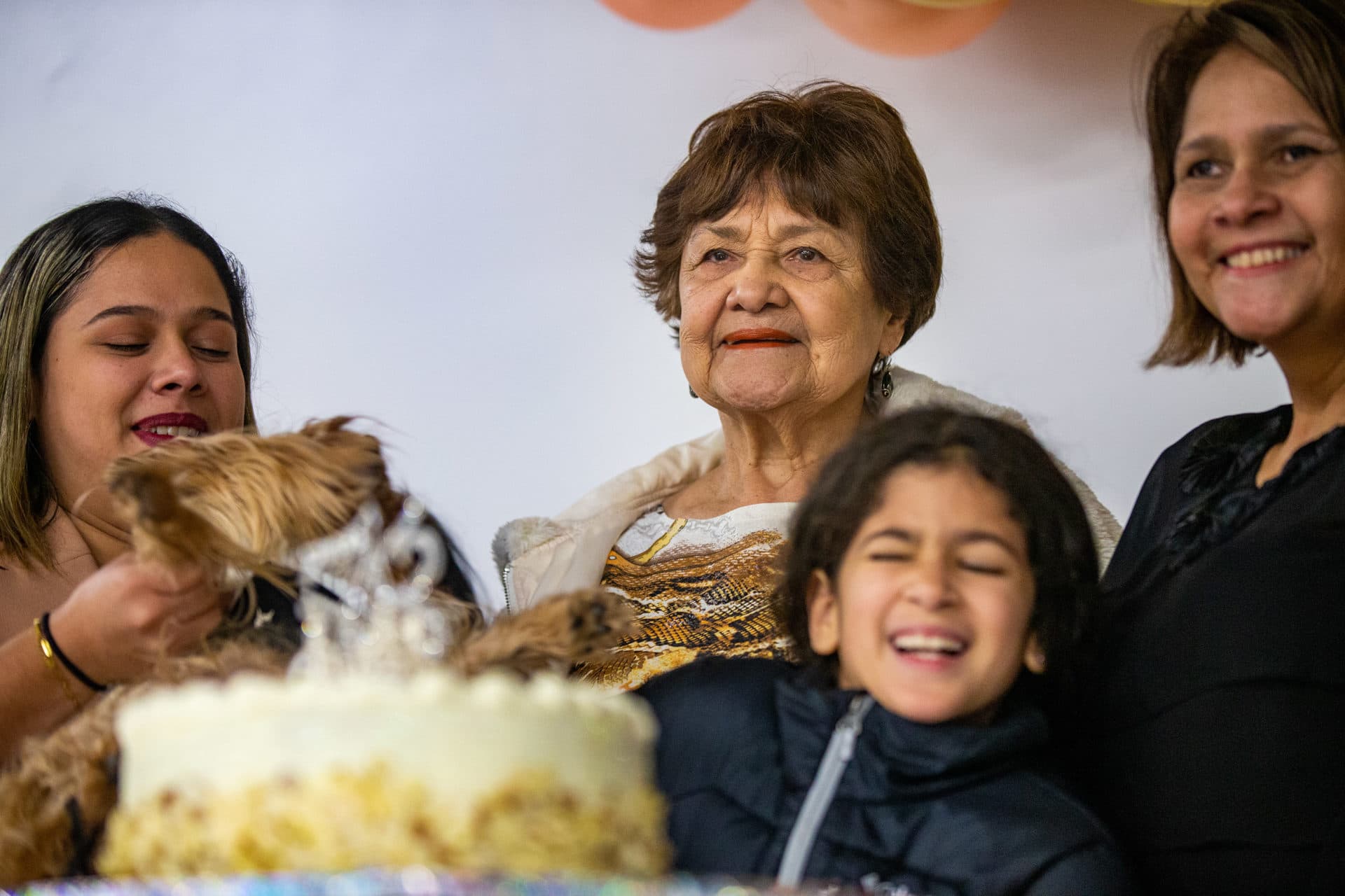 Isabel Rodriguez's mother, center, celebrates her 78th birthday with extended family that recently began living with them near Worcester after fleeing Venezuela. (Jesse Costa/WBUR)