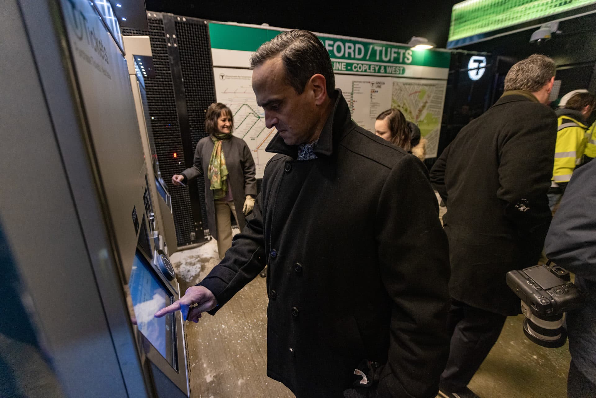 Former Somerville Mayor Joe Curtatone and current Somerville Mayor Katjana Ballantyne purchase fares before riding the first train on the Green Line Extension into Somerville. (Jesse Costa/WBUR)