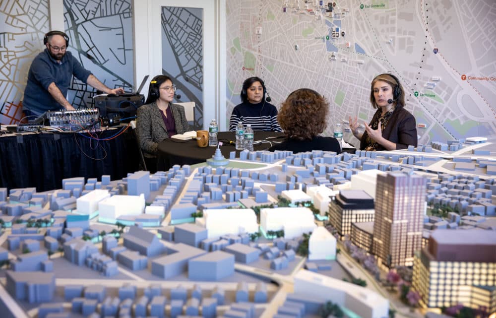 Surrounded by maps and model of Union Square, Radio Boston host Tiziana Dearing speaks with guests Nicole Eigbrett, Jen Palacio and Jess Willis at live broadcast from USQ's office in Union Square. (Robin Lubbock/WBUR)